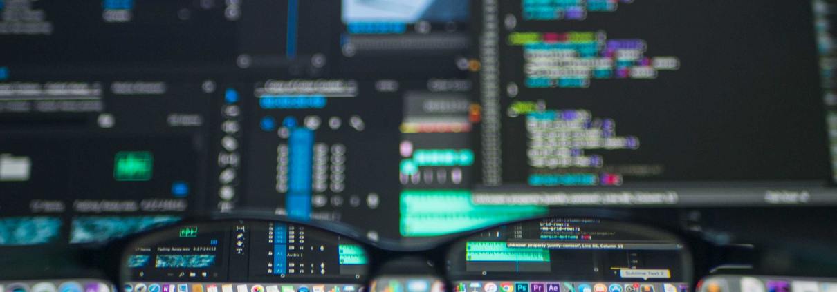 Der Bildschirm eines Computers, mit dem gerade gecodet wird. Im Vordergrund eine Brille.