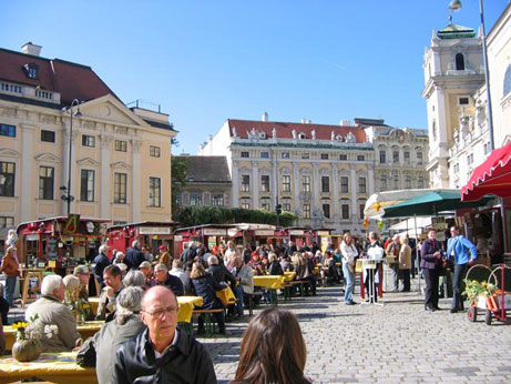 Marktplatz mit Ständen, Tischen und vielen Menschen