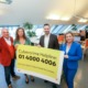 4 Personen halten Plakat mit Infos zur Cybercrime Helpline