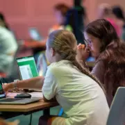 2 Mädchen sitzen vor Laptops