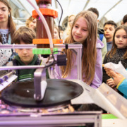 Kinder und Jugendliche betrachten einen experimentalen Aufbau.