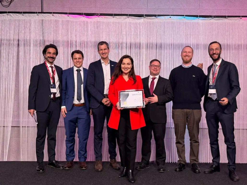 Preisverleihung, im Vordergrund eine Frau mit Preis, dahinter 6 Männer