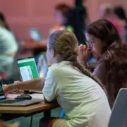 2 junge Mädchen sitzen vor ihren Laptops