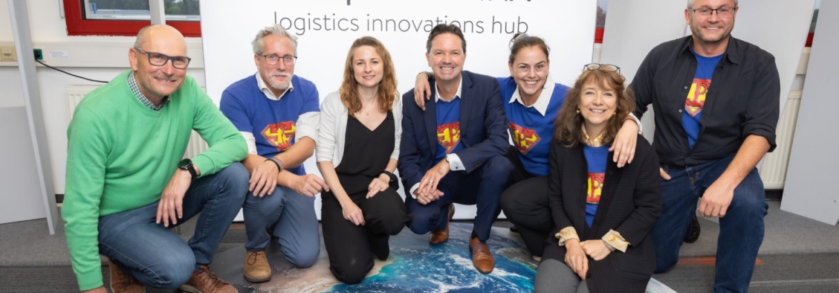 Ein Team posiert für ein Foto auf einem Bild der Erde.