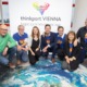 Ein Team posiert für ein Foto auf einem Bild der Erde.