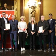 Gruppe von Menschen, einige mit einer Urkunde in der Hand