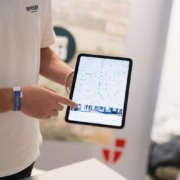 Jemand zeigt mit einem Finger auf eine App am Tablet